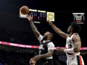 Los Angeles Clippers forward P.J. Tucker, left shoots the ball over Portland Trail Blazers guard Scoot Henderson, right, during the first half of an NBA basketball game in Portland, Ore., Friday, March 22, 2024.