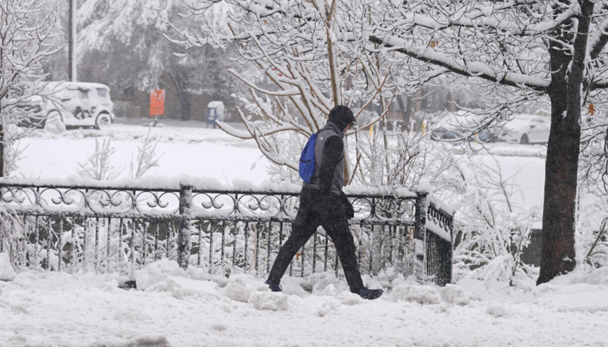 A pedestrian moves along Speer Boulevard as a late winter storm dropped up to a foot of snow Thursday, March 14, 2024, in Denver. Forecasters predict that the storm will persist until early Friday, snarling traffic along Colorado&#039;s Front Range communities.