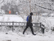 A pedestrian moves along Speer Boulevard as a late winter storm dropped up to a foot of snow Thursday, March 14, 2024, in Denver. Forecasters predict that the storm will persist until early Friday, snarling traffic along Colorado&#039;s Front Range communities.