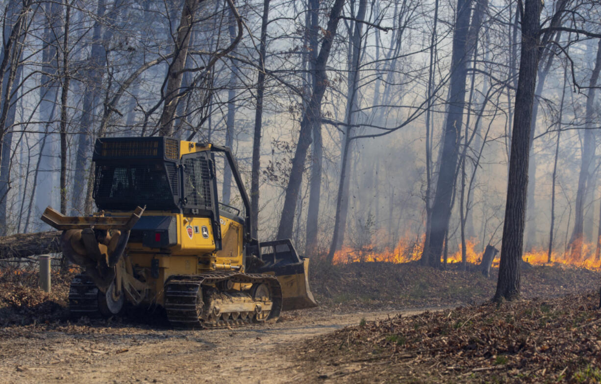 A Virginia Department of Forestry bulldozer cuts a fire line during a wildfire along Brushy Run Road on Wednesday in Bergton, Va.