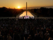FILE -  The word &ldquo;Jesus&rdquo; is displayed on a large monitor and worship songs are played on stage as people gather for the &ldquo;Easter Sunrise Service&rdquo; at the Lincoln Memorial, Sunday, April 9, 2023, in Washington, hosted by the National Community Church. On Easter morning, many Christians wake before dawn. They will celebrate their belief in the resurrection of Jesus, the son of God, as the sun rises.