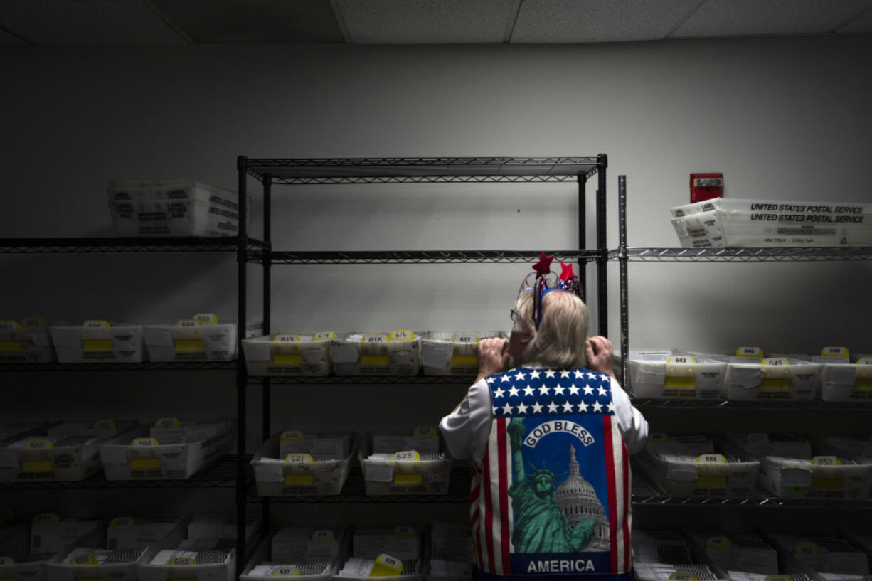 Election worker Wendy Wimer looks through vote-by-mail ballots during the presidential primary election on Tuesday, March 12, 2024, at the Clark County Elections Office in Vancouver, Wash.