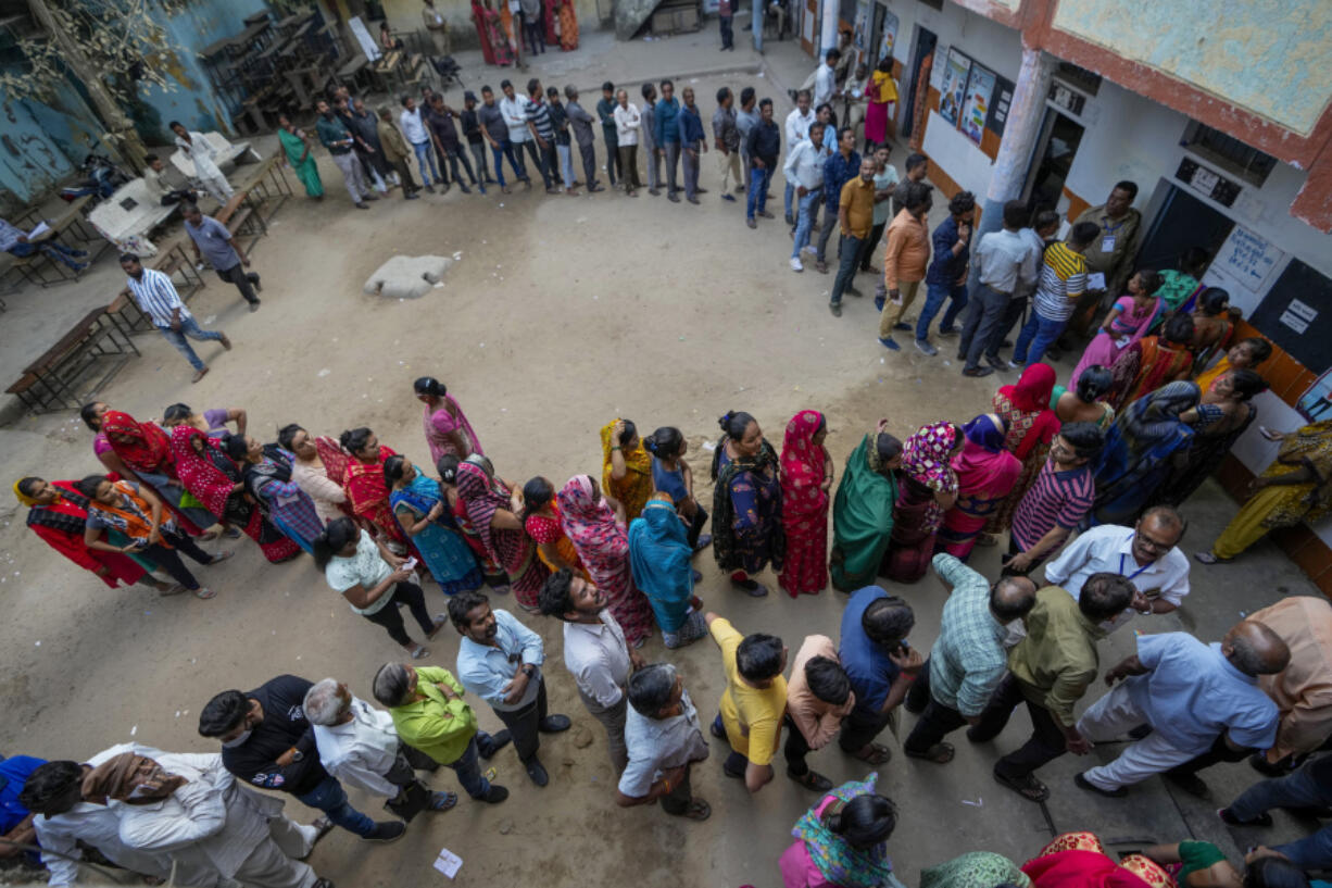 FILE - People stand in queue to cast their votes during the second phase of Gujarat state legislature elections in Ahmedabad, India, Dec. 5, 2022. From April 19 to June 1, nearly 970 million Indians - or over 10% of the world&rsquo;s population - will vote in the country&rsquo;s general elections. It&rsquo;s one of several high-profile elections around the world this year that are highlighting concerns about online election misinformation.