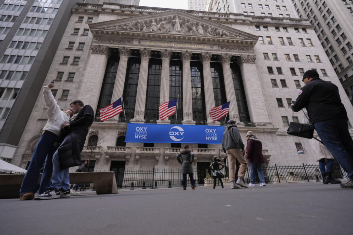 Tourists pose for photographs outside of the New York Stock Exchange, Tuesday, Feb. 27, 2024, in New York.