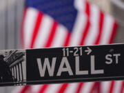 A street sign is seen in front of the New York Stock Exchange the New York Stock Exchange, Tuesday, Feb. 27, 2024, in New York. Stocks are holding relatively steady on Wall Street near their record levels.