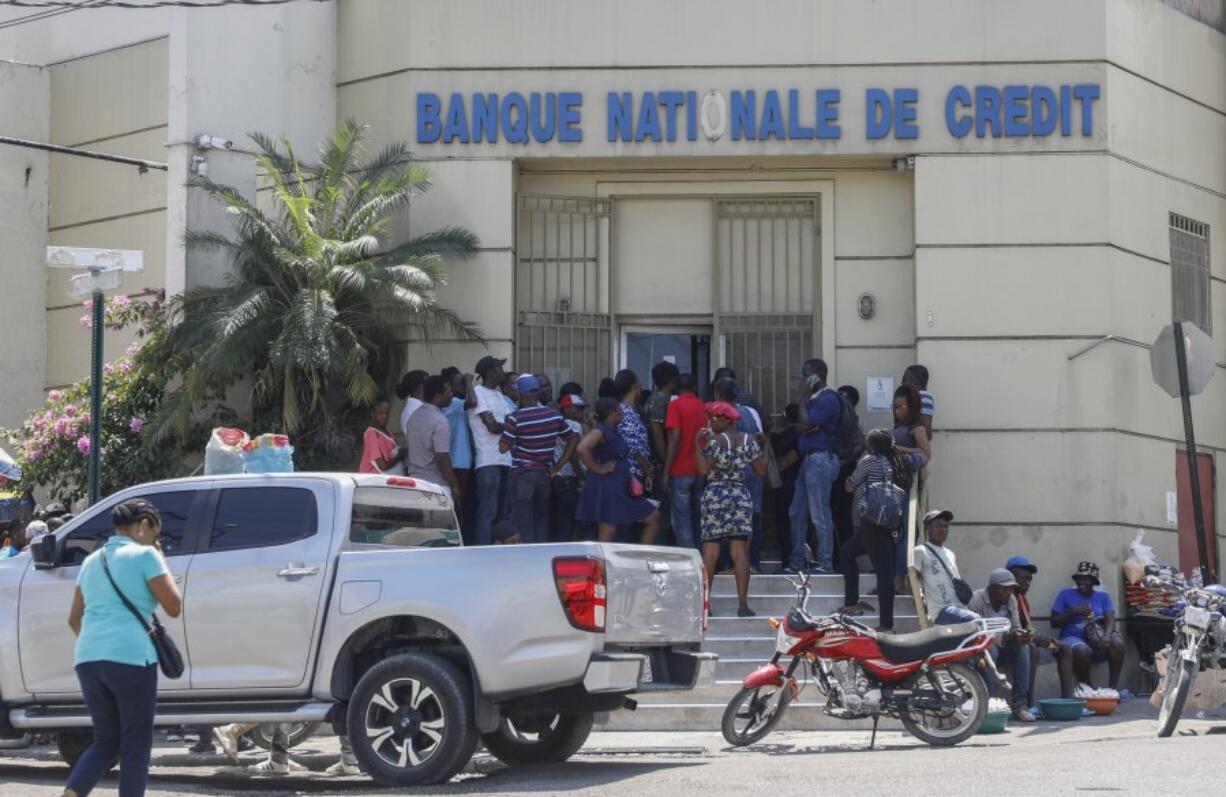 People line up outside a bank that had been closed for several days due to violence Wednesday in Port-au-Prince, Haiti.