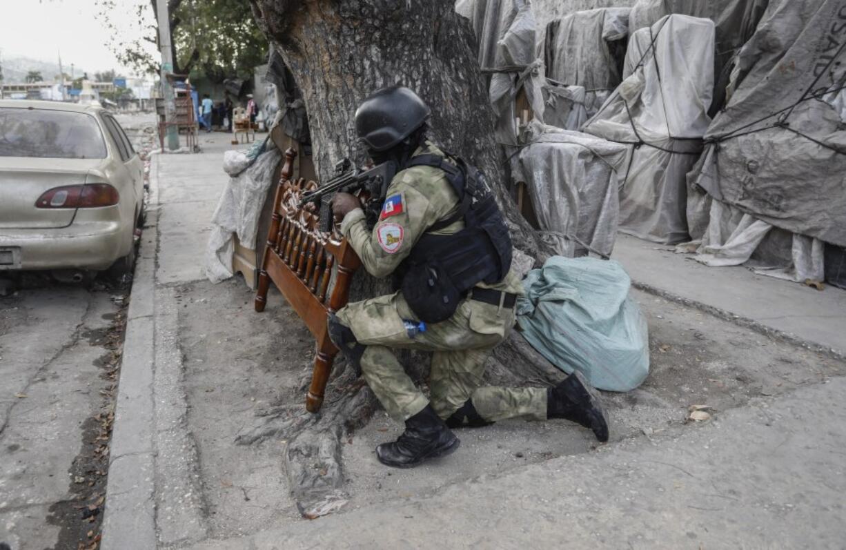 Police take cover during an anti-gang operation at the Portail neighborhood of Port-au-Prince, Haiti, Thursday, Feb. 29, 2024. Gunmen shot at the international airport and other targets in a wave of violence that forced businesses, government agencies and schools to close early.
