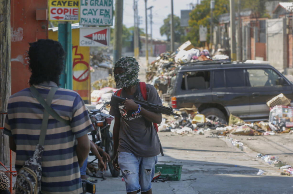Armed members of the G9 and Family gang stand guard at their roadblock Monday in the Delmas 6 neighborhood of Port-au-Prince, Haiti.