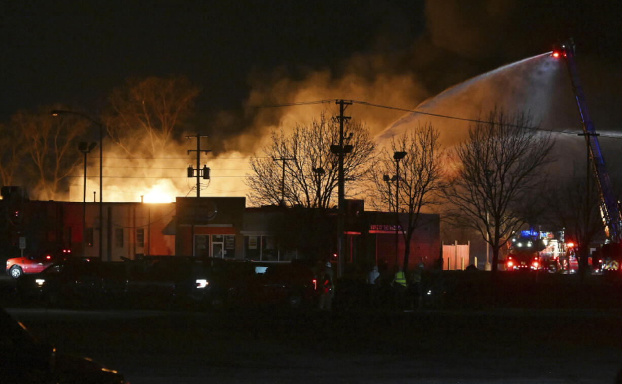 Fire departments fight an industrial fire near 15 Mile Road and Groesbeck Highway in Clinton Township, Mich., on Monday, March 4, 2024.