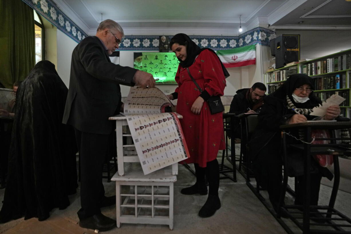 Voters fill out their ballots during the parliamentary and Assembly of Experts elections at a polling station in Tehran, Iran, Friday, March 1, 2024. Iran on Friday held the country&rsquo;s first election since the mass 2022 protests over mandatory hijab laws after the death in police custody of Mahsa Amini, with questions looming over just how many people will turn out at the polls.