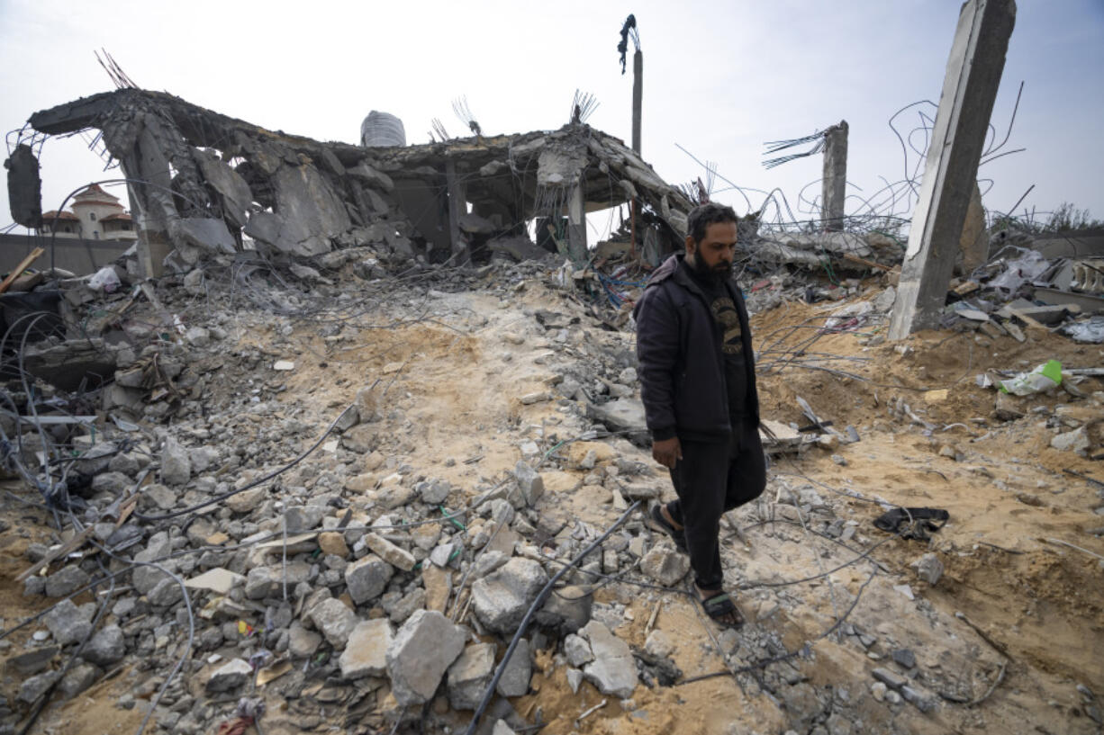 Palestinians look at a house destroyed in an Israeli strike in Rafah, Gaza Strip on Tuesday, March 26, 2024.