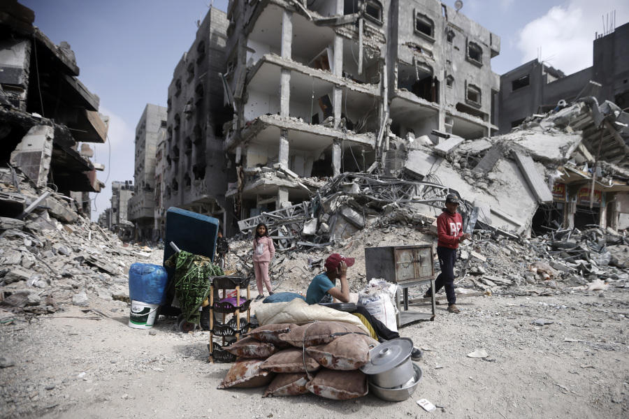 Palestinians sit by their belonginsg after visiting their houses destroyed in the Israeli offensive on Khan Younis, Gaza Strip, Wednesday, March 6, 2024.