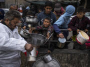 Palestinians line up for free food in Rafah, Gaza Strip, Friday, Feb. 23, 2024.