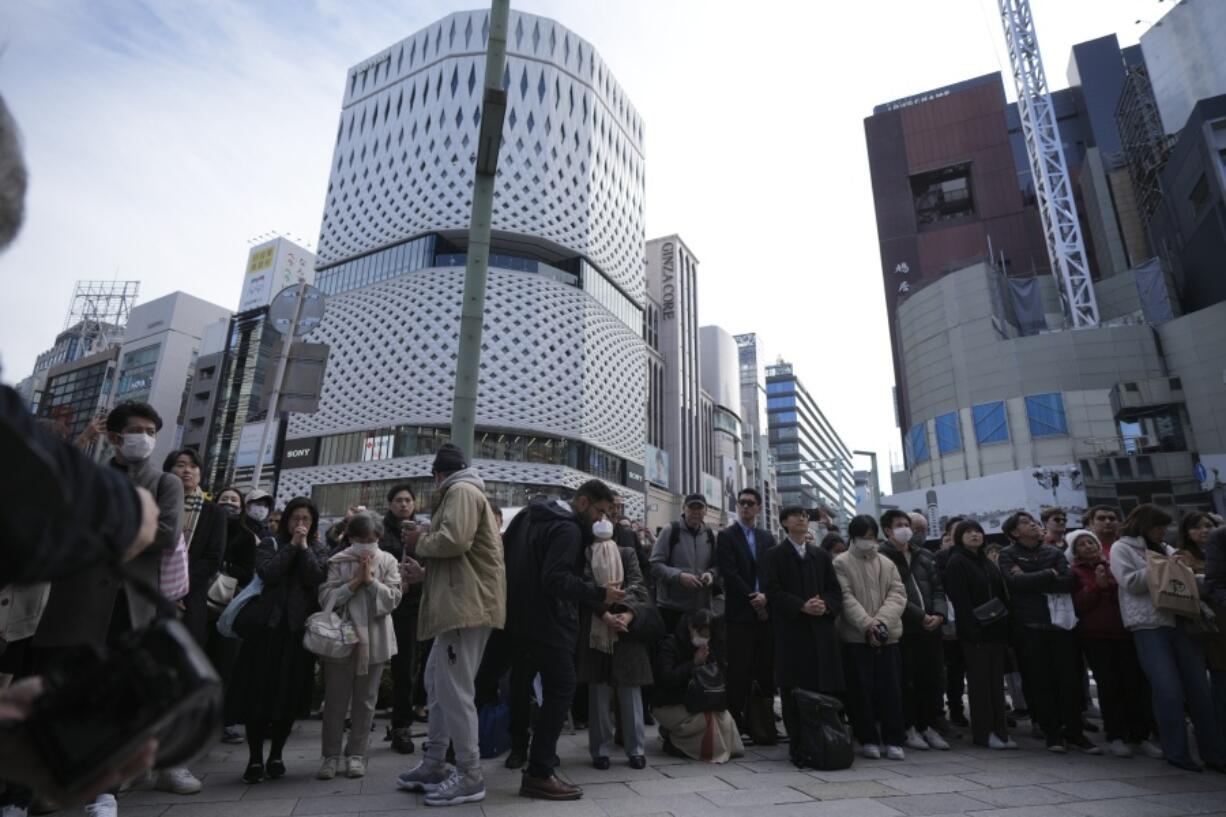 Bystanders gather when an annual tribute started at 2:46 p.m. for the victims of a 2011 disaster Monday, March 11, 2024, in Tokyo. Japan on Monday marked the 13th anniversary of the massive earthquake, tsunami and nuclear disaster that struck Japan&rsquo;s northeastern coast.