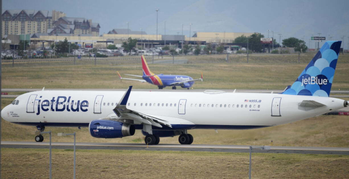 FILE - A Jet Blue jetliner taxis down a runway as a Southwest Airlines airliner takes off from Denver International Airport Tuesday, July 5, 2022, in Denver.  Shares of JetBlue are rising more than 15% before the market open on Tuesday, Feb. 13, 2024,  as activist investor Carl Icahn took an almost 10% stake in the airline.