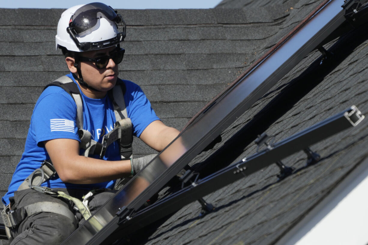 A technician installs solar panels on a roof of a home in Arlington Heights, Ill., Monday, Feb. 26, 2024. On Wednesday, March 6, 2024, the Labor Department reports on job openings and labor turnover for January. (AP Photo/Nam Y.