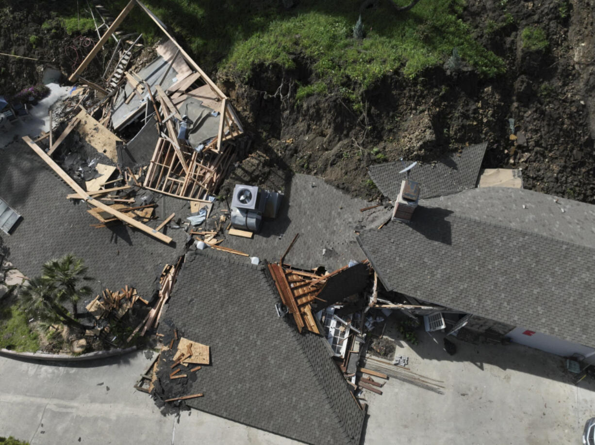 An aerial view shows a property damaged by a landslide, Wednesday, March 13, 2024, in the Sherman Oaks section of Los Angeles. A landslide has destroyed the hillside home and is imperiling at least two others in Los Angeles. (AP Photo/Jae C.