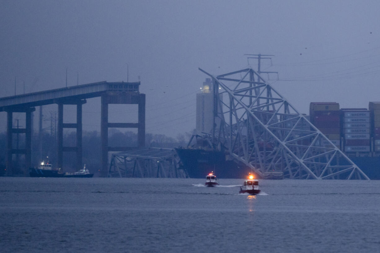 A container ship rests against wreckage of the Francis Scott Key Bridge near sunrise on Wednesday, March 27, 2024, in Baltimore, Md. Recovery efforts resumed Wednesday for the construction workers who are presumed dead after the cargo ship hit a pillar of the bridge, causing the structure to collapse.