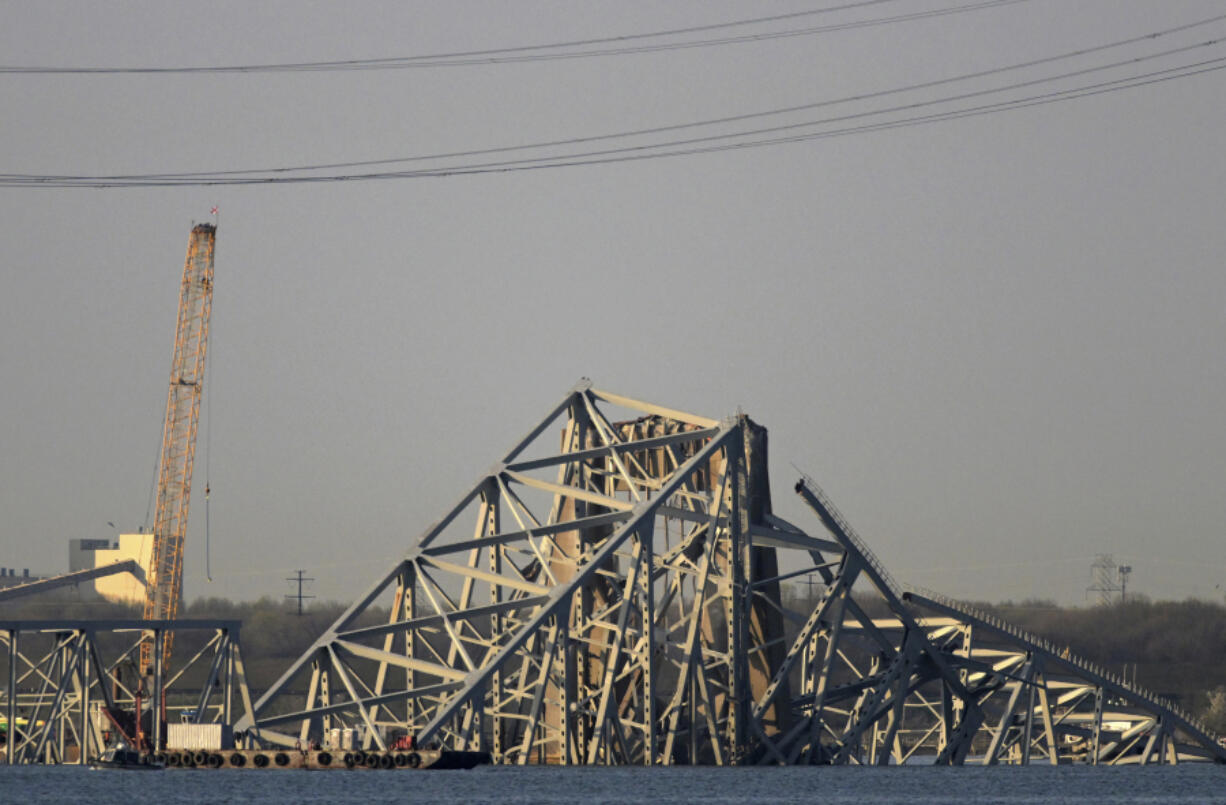 A crane is seen near the wreckage of the Francis Scott Key Bridge on Friday, March 29, 2024 in Baltimore. A cargo ship rammed into the major bridge in Baltimore early Tuesday, causing it to collapse in a matter of seconds.