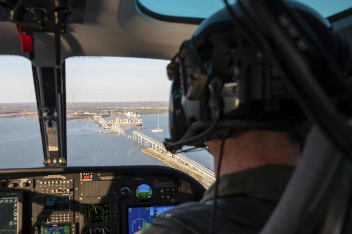 In this photo provided by the U.S. Coast Guard, a Maryland Natural Resources Police officer conducts an overflight assessment of the M/V Dali, a 948-foot Singapore-flagged container ship, and Francis Scott Key Bridge in the Patapsco River in Baltimore, Saturday, March 30, 2024. The Unified Command continues to coordinate response operations for the bridge while safeguarding the welfare of both the public and first responders. (Petty Officer 3rd Class Kimberly Reaves/U.S.