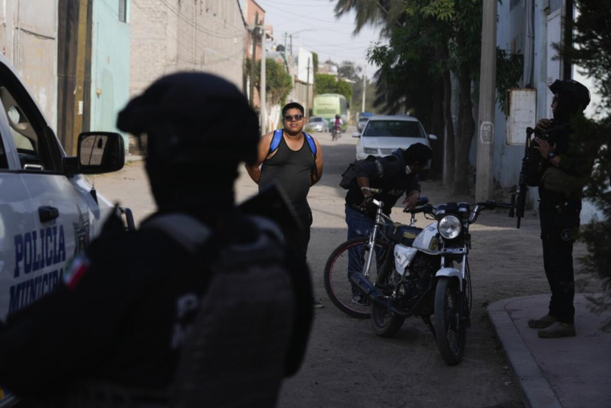 A man answers questions during a stop and search by municipal police in a neighborhood of Celaya, Mexico, Wednesday, Feb. 28, 2024.