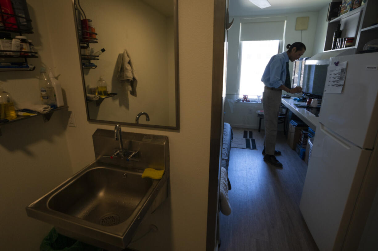 Cheyenne Welbourne is seen March 15 standing at his micro-apartment&rsquo;s kitchenette in the Starlight affordable housing building that is run by Central City Concern, a Portland-based homeless services nonprofit, in Portland.