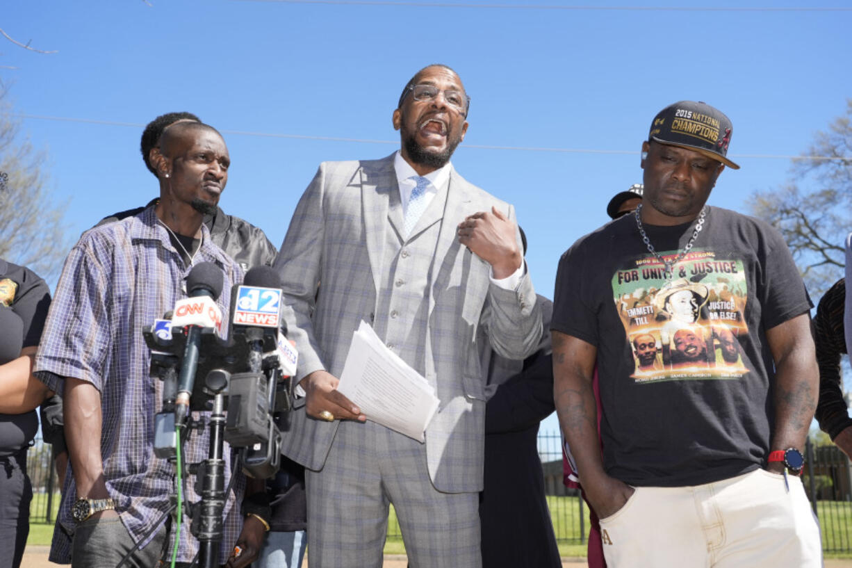Michael Corey Jenkins, left, and Eddie Terrell Parker, right, stand with lead attorney Malik Shabazz, as he calls on a federal judge, Monday, March 18, 2024, to impose the harshest possible penalties against six former Mississippi Rankin County law enforcement officers who committed numerous acts of racially motivated, violent torture on them in 2023. They spoke at a news conference in Jackson, Miss. The six former law officers pleaded guilty to a number of charges for torturing them and they will be sentenced in federal court on Tuesday. (AP Photo/Rogelio V.
