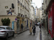 A mosaic by French artist Invader, top left, decorates a Paris street.