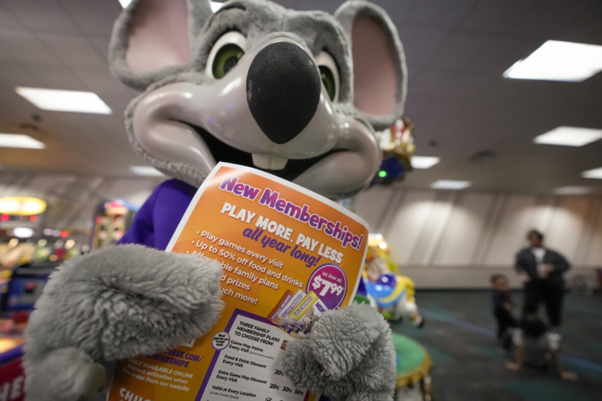 An employee dressed as Chuck E. Cheese holds a flyer advertising new memberships at a location Wednesday, March 13, 2024, in San Diego. Paid loyalty programs are all the rage in the restaurant and retail world. Looking for reliable sales in an unpredictable spending environment, more companies have extended their points-based loyalty tiers to making their most dependable customers feel valued for an up-front fee.