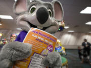 An employee dressed as Chuck E. Cheese holds a flyer advertising new memberships at a location Wednesday, March 13, 2024, in San Diego. Paid loyalty programs are all the rage in the restaurant and retail world. Looking for reliable sales in an unpredictable spending environment, more companies have extended their points-based loyalty tiers to making their most dependable customers feel valued for an up-front fee.