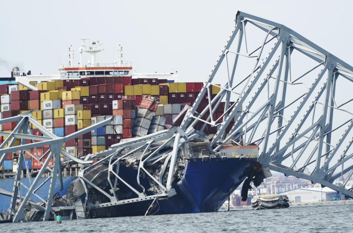 A cargo ship is stuck under the part of the structure of the Francis Scott Key Bridge after the ship hit the bridge, Tuesday March 26, 2024, in Baltimore, Va.