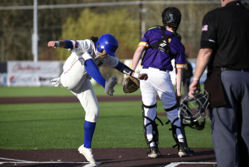Ridgefield's Deven Savella, left, celebrates a run scored by stomping his foot at home plate during the Spudders' 2A Greater St. Helens League baseball game against Columbia River on Friday, March 29, 2024, at Ridgefield Outdoor Recreation Complex.