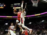 Houston Rockets guard Jalen Green (4) goes up for a dunk against Portland Trail Blazers guard Anfernee Simons, right, during the second half of an NBA basketball game in Portland, Ore., Friday, March 8, 2024.