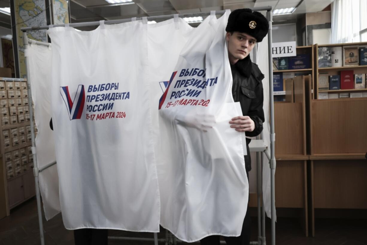 A student of the Maritime State University named after admiral Gennady Nevelskoy leaves a voting booth at a polling station during a presidential election in the Pacific port city of Vladivostok, 6,418 km (3,566 miles) east of Moscow, Russia, Friday, March 15, 2024. Voters in Russia headed to the polls for a presidential election that was all but certain to extend President Vladimir Putin&#039;s rule after he clamped down on dissent.