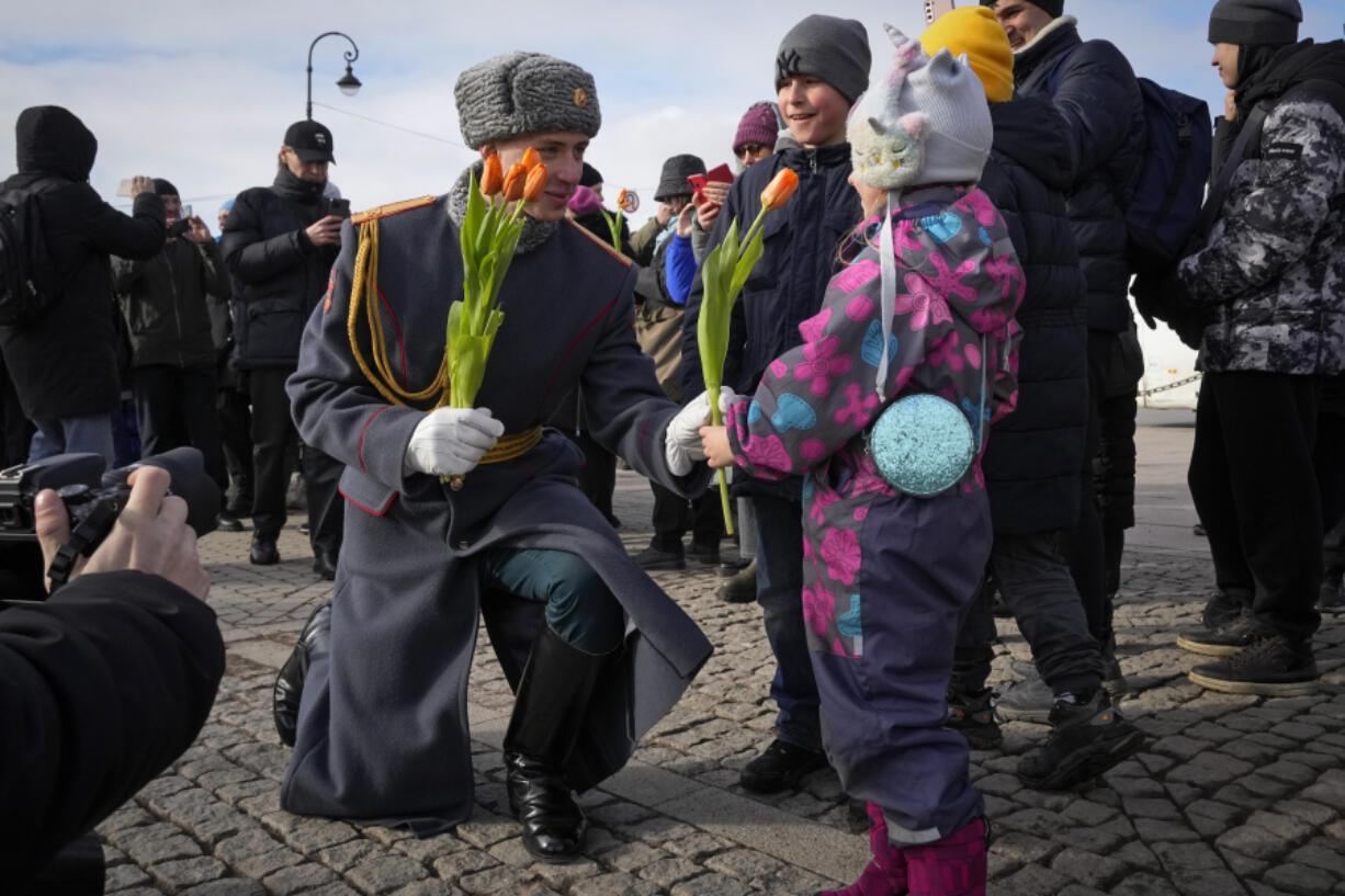 A honour guard soldier gives a flower to a girl on International Women&rsquo;s Day in St. Petersburg, Russia, Friday, March 8, 2024. International Women&rsquo;s Day on March 8 is an official holiday in Russia. Per tradition, men give flowers and gifts to female relatives, friends and colleagues, even though in the past two years flowers have gotten more expensive. Marches, demonstrations and conferences are being held the world over, from Asia to Latin America and elsewhere.