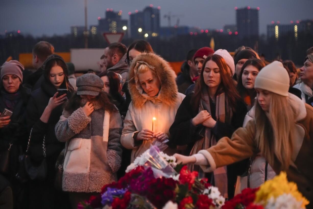 People lay flowers and light candles standing next to the Crocus City Hall, on the western edge of Moscow, Russia, Saturday, March 23, 2024. Russia&#039;s top state investigative agency says the death toll in the Moscow concert hall attack has risen to over 133. The attack Friday on Crocus City Hall, a sprawling mall and concert venue on Moscow&#039;s western edge, also left many wounded and left the building a smoldering ruin.