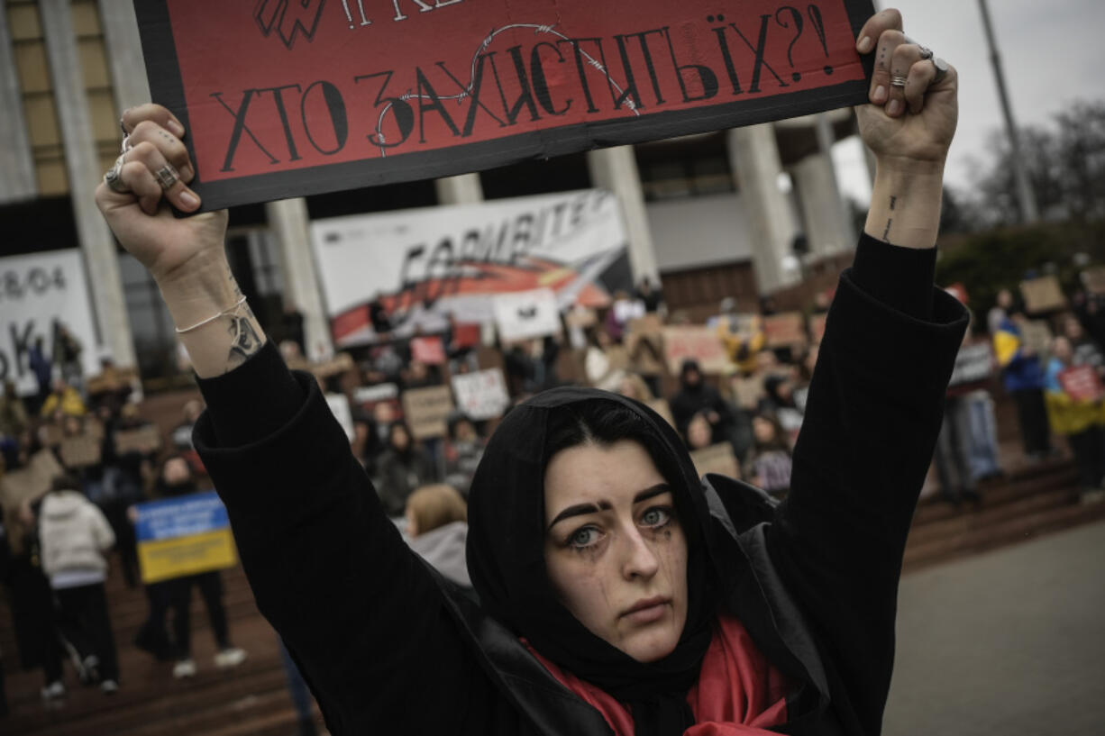 A woman holds a sign during a protest Sunday in Kyiv, Ukraine, to demand the release of Ukrainian defenders still being held prisoner by Russia.