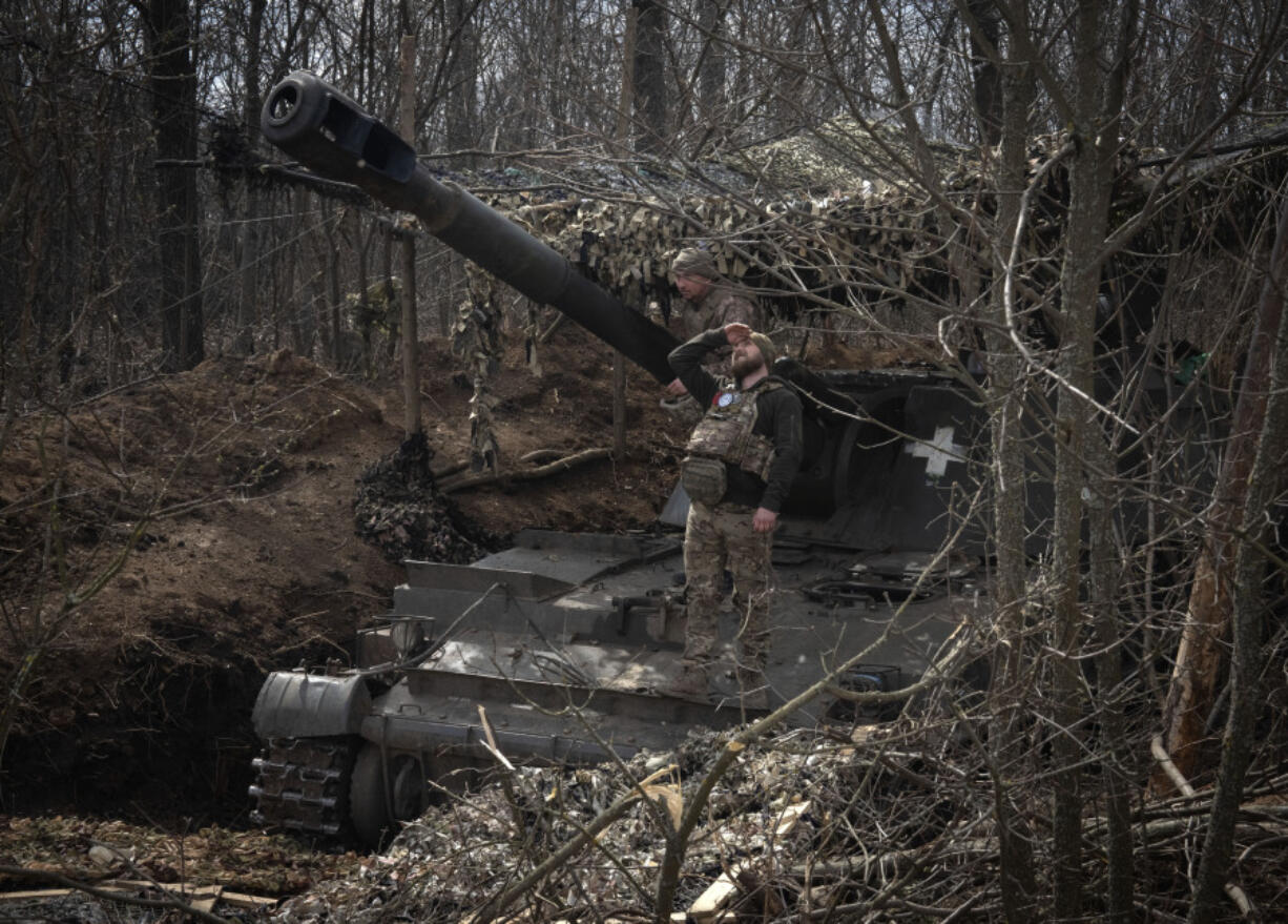 A Ukrainian soldier looking for a visual confirmation of drone-free sky, as he prepares to fire 152-mm Self-Propelled Howitzer 2S3, towards Russian positions at the frontline, near Bakhmut, Donetsk region, Ukraine, Monday, March 25, 2024.