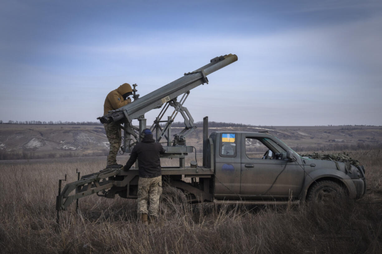 FILE - Ukrainian soldiers from The 56th Separate Motorized Infantry Mariupol Brigade prepare to fire a multiple launch rocket system based on a pickup truck towards Russian positions at the front line, near Bakhmut, Donetsk region, Ukraine, March 5, 2024. Senior U.S. defense officials said Tuesday, March 12, that the Pentagon will rush about $300 million in weapons to Ukraine after finding some cost savings in its contracts, even though the military remains deeply overdrawn.