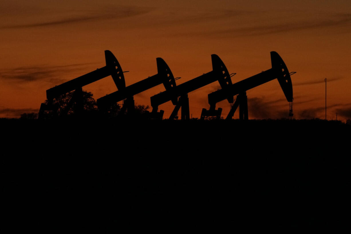 Oil pump jacks operate at dusk near Barnes City, Texas, Wednesday, Nov. 1, 2023. The U.S. Securities and Exchange Commission weakened a proposed climate disclosure rule after strong pushback from companies and others, and will no longer require companies to report some greenhouse gas emissions.