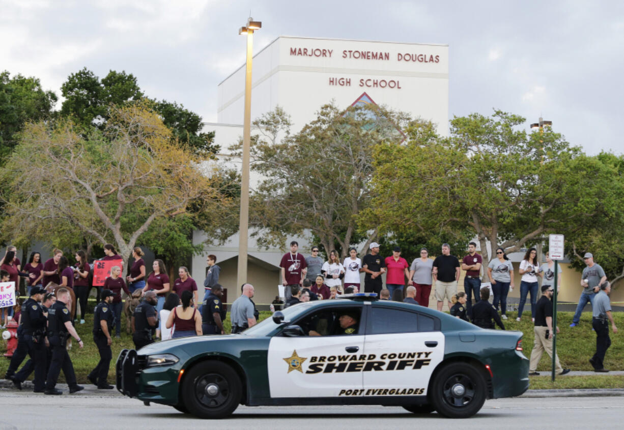 FILE - In this Feb. 28, 2018 file photo, a police car drives near Marjory Stoneman Douglas High School in Parkland, Fla., as students return to class for the first time since a former student opened fire there with an assault weapon.  Mass shootings at schools have prompted a growing number of states to encourage the creation of digital maps of facilities to aid emergency responders. An Associated Press analysis found that governors and lawmakers in more than 20 states have enacted or proposed measures setting standards for digital school mapping.