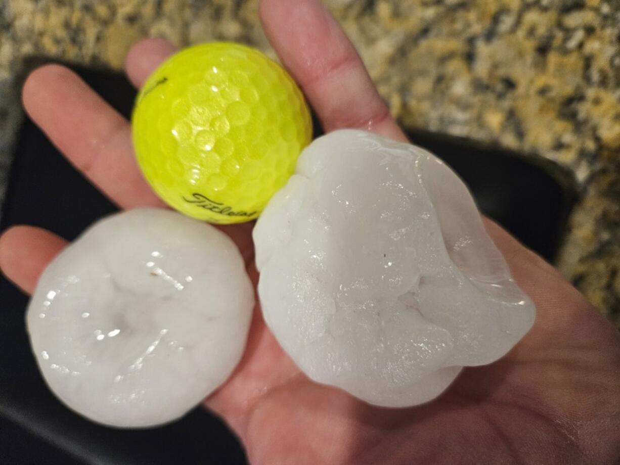 In this provided image, chunks of hail are compared to a golf ball Wednesday night in Shawnee, Kan.