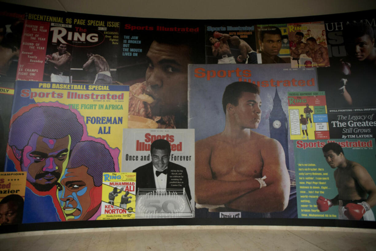 FILE - Large posters of mostly Sports Illustrated magazine covers are displayed at the &ldquo;I Am The Greatest, Muhammad Ali&rdquo; exhibition at the O2 arena, which hosts high profile boxing fights in London, June 4, 2016. Sports Illustrated will continue operations after the company that owns the brand reached an agreement with a new publisher for its print and digital products, Monday, March 18, 2024.