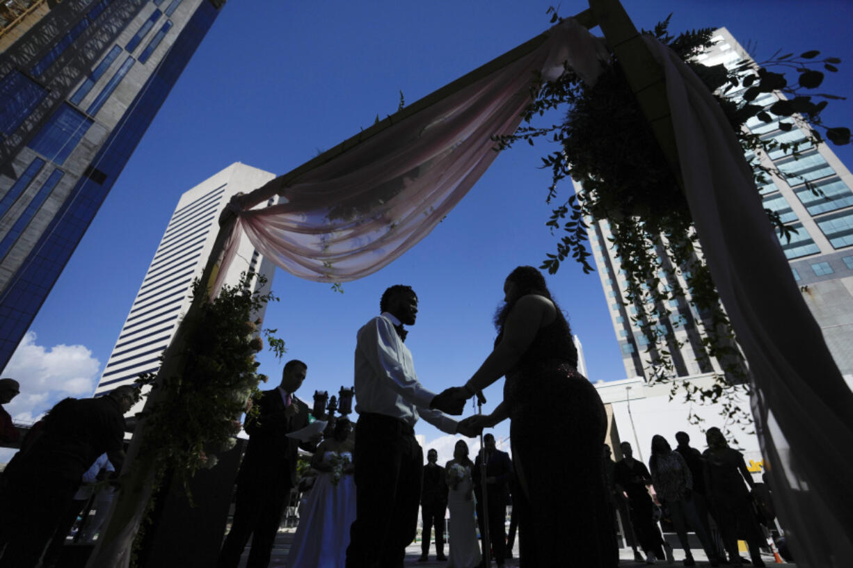 FILE - A couple holds hands as they are married by a county clerk during a Valentine&#039;s Day group wedding ceremony on the steps of the Dade County Courthouse in Miami, Wednesday, Feb. 14, 2024. U.S. marriages have rebounded to pre-pandemic levels with nearly 2.1 million in 2022, a 4% increase from the year before, the Centers for Disease Control and Prevention said in a report published Friday, March 15, 2024.