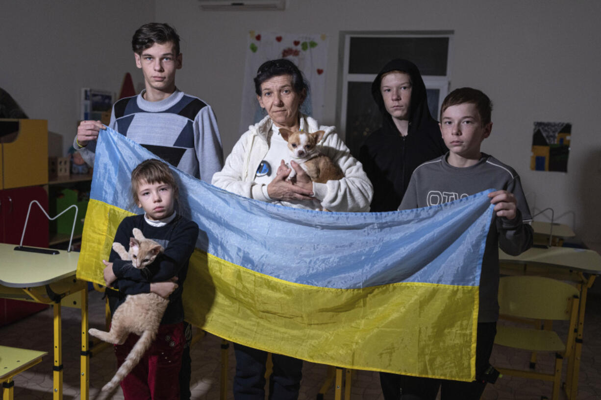 Natalia Zhyvohliad, an internally displaced person from Nova Petrivka in the Zaporizhzhia region of Ukraine, poses with some of her children at the IDP shelter in Kyiv, Friday, Jan. 19, 2024.