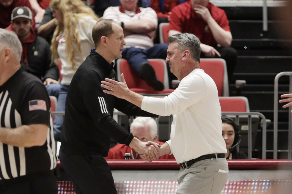 Washington head coach Mike Hopkins, center left, and Washington State head coach Kyle Smith, center right, greet each other after a game Thursday in Pullman. Smith has been touted as a replacement for Hopkins after leading the Cougars to second in the Pac-12.