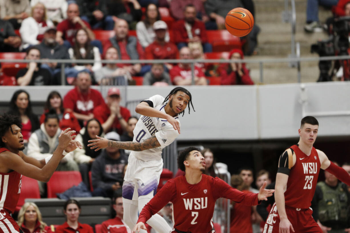 Washington guard Koren Johnson (0) passes the ball next to Washington State guard Myles Rice (2) during the second half of an NCAA college basketball game, Thursday, March 7, 2024, in Pullman, Wash.