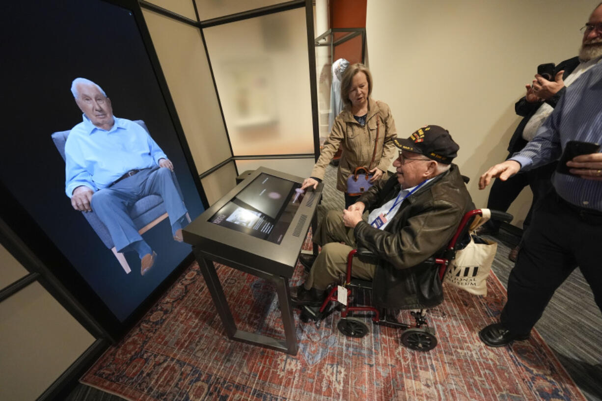 World War II veteran Olin Pickens of Nesbit, Miss., who served in the U.S. Army 805th Tank Destroyer Battalion, looks at the virtual exhibit of himself Wednesday at the National World War II Museum in New Orleans. An interactive exhibit uses artificial intelligence to let visitors hold virtual conversations with images of veterans, including a Medal of Honor winner who died in 2022.