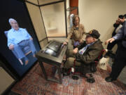 World War II veteran Olin Pickens of Nesbit, Miss., who served in the U.S. Army 805th Tank Destroyer Battalion, looks at the virtual exhibit of himself Wednesday at the National World War II Museum in New Orleans. An interactive exhibit uses artificial intelligence to let visitors hold virtual conversations with images of veterans, including a Medal of Honor winner who died in 2022.