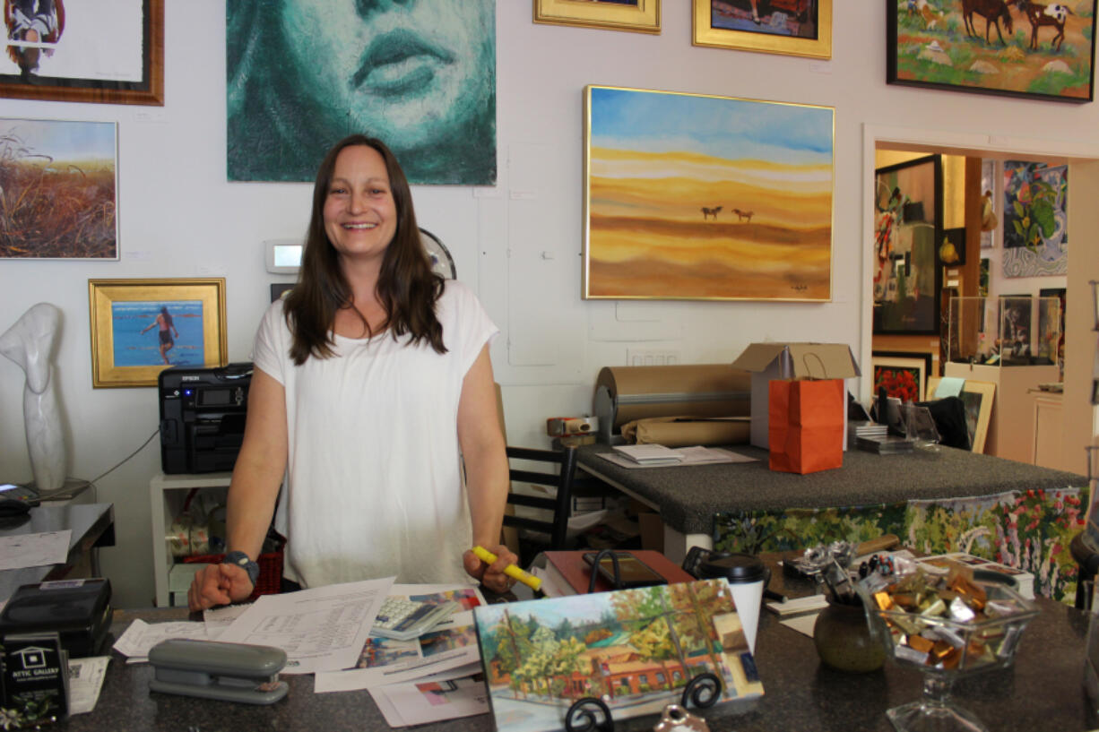 Maria Gonser behind her desk at the Attic Gallery. Because of pressing family obligations and strong internet business, Gonser said, the gallery in Camas will close while its website remains alive.